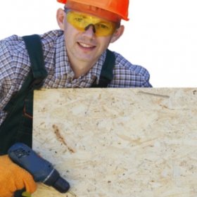 Gradbeni mojster drži leseno ploščo